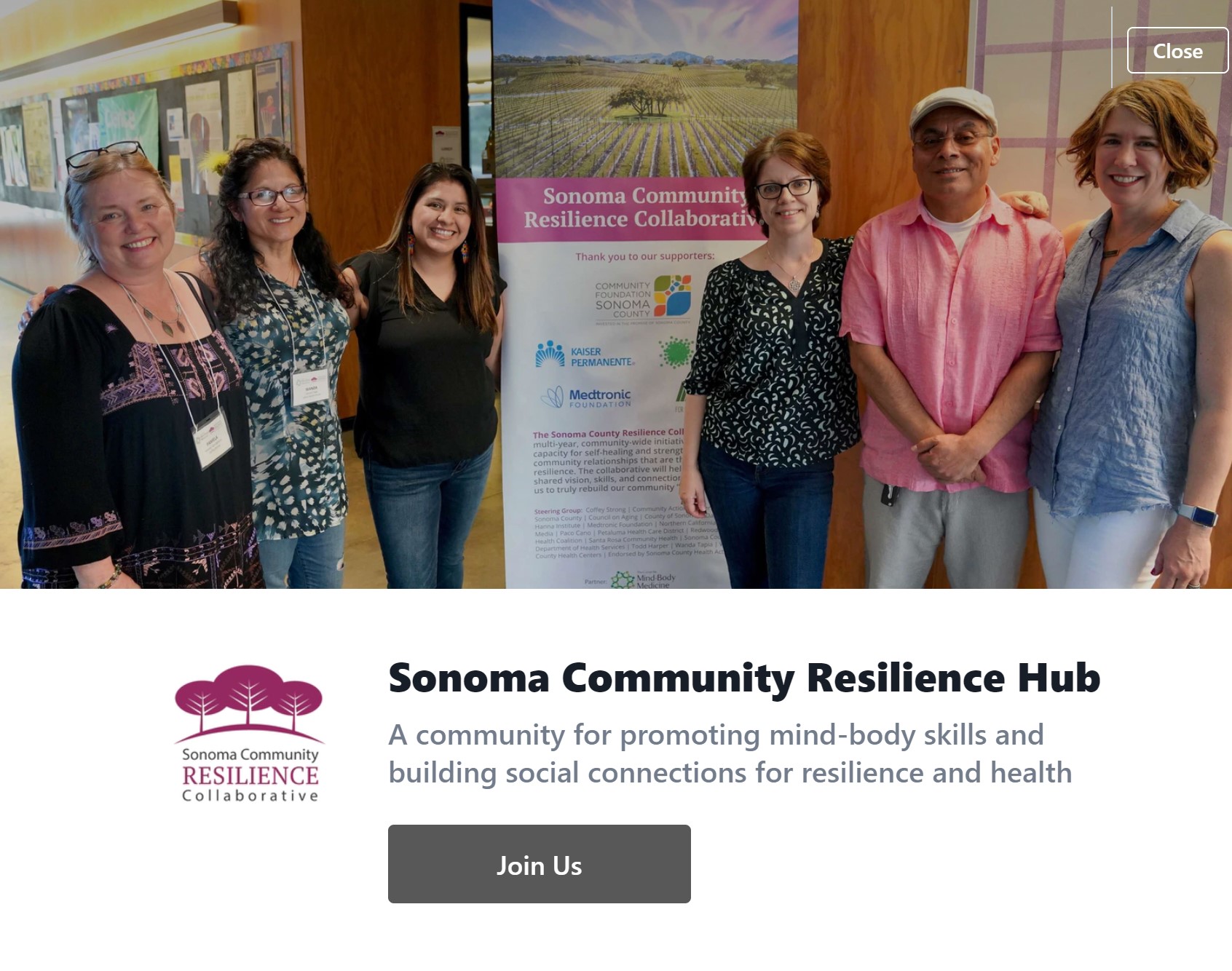 Santa Rosa Community Health Center employees gathered around a Sonoma Community Resilience Hub poster.
