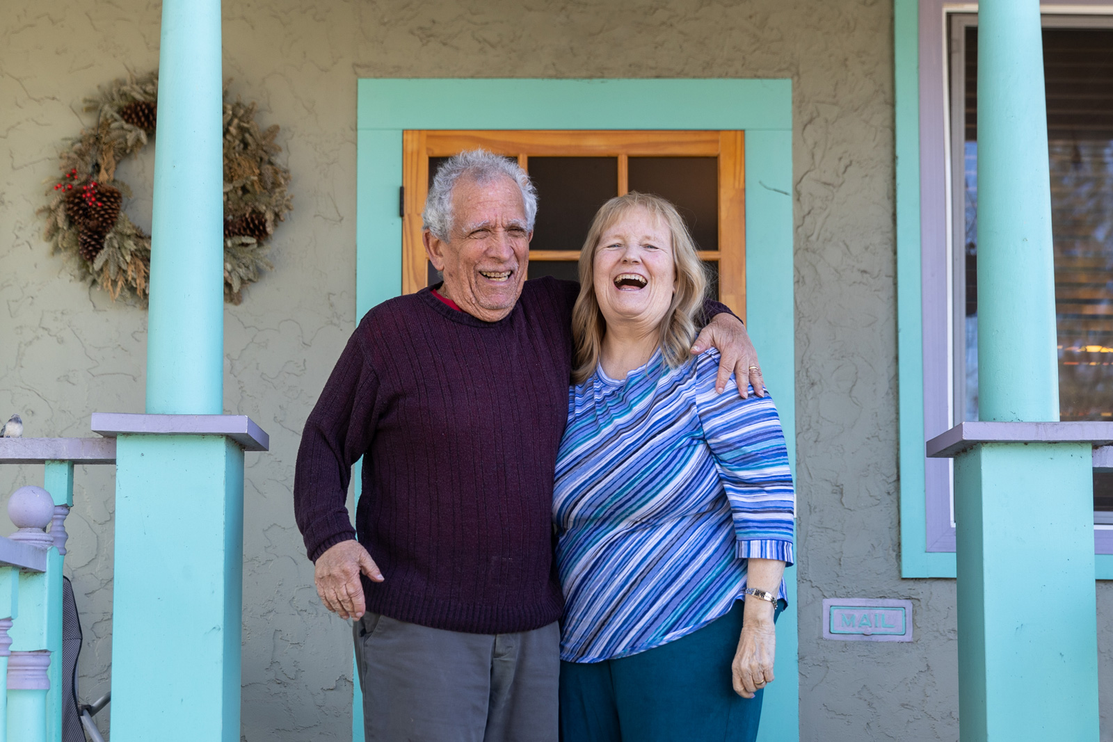 Sam and Betz Miller laugh as they hug one another on the front porch of their Santa Rosa home.