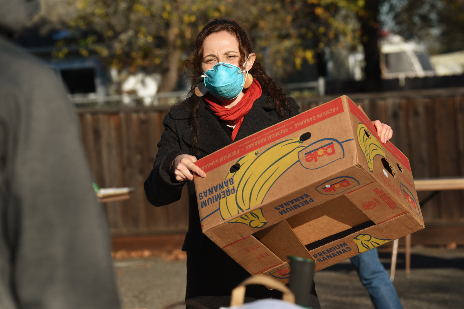 California Homemakers Association volunteer carrying a cardboard box.