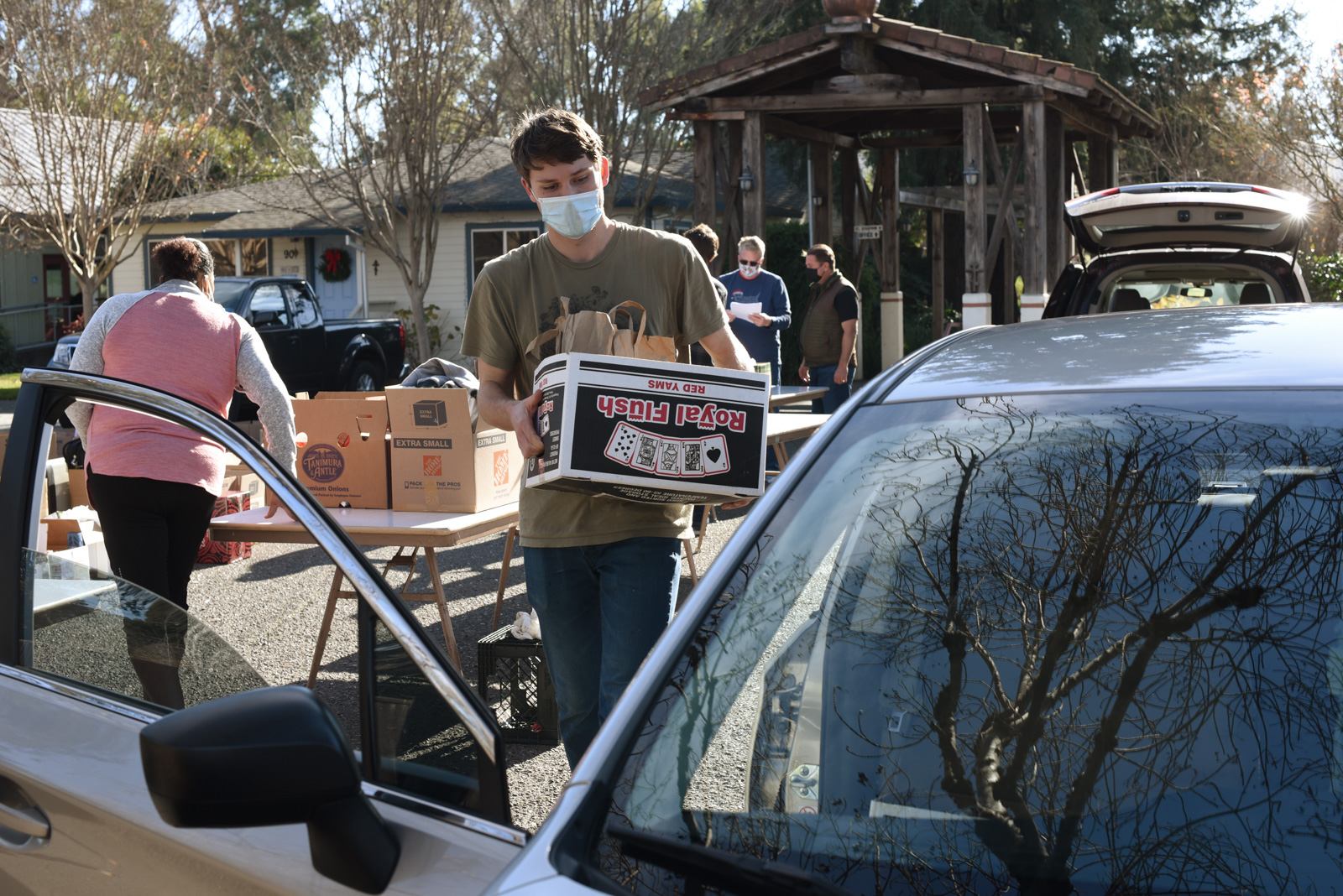 California Homemakers Association driver volunteer loading his car with a box of food for Santa Rosa community members.