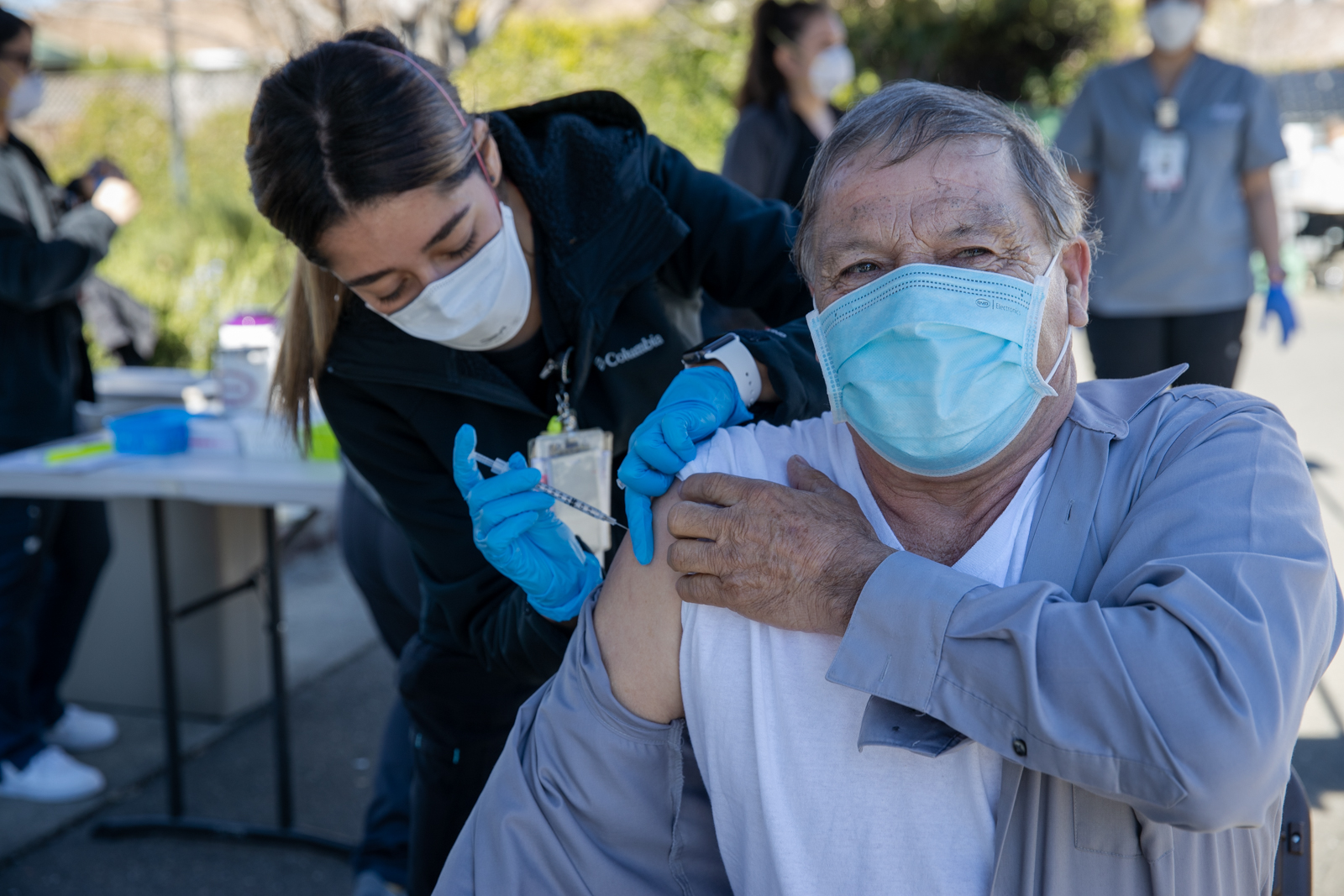 An elder community member receiving a COVID-19 vaccine.