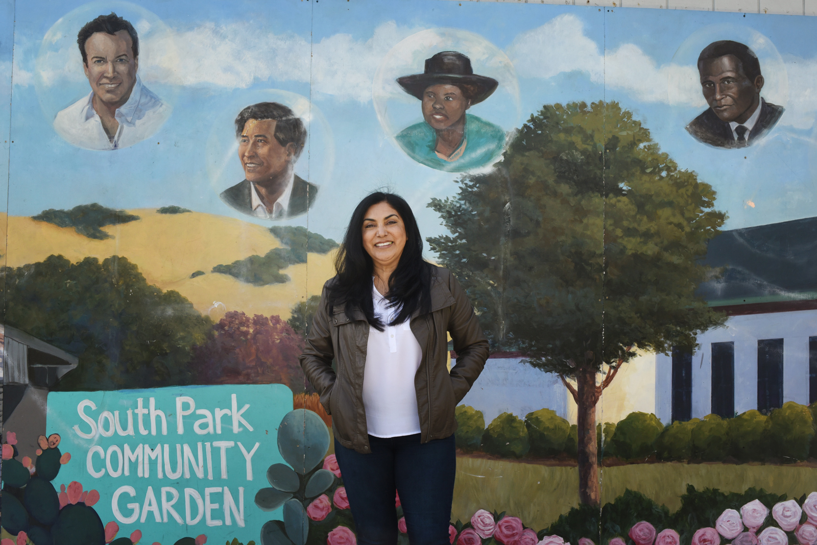 Kathy Kane, Director of Services for Community Action Partnership, stands in front of a mural at the South Park Community Garden in Santa Rosa